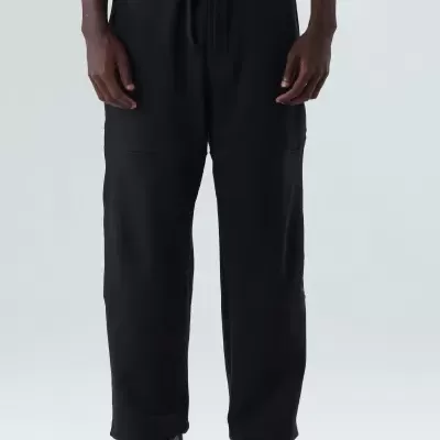 Calças pretas com cordão na cintura e sapatos pretos sobre fundo branco