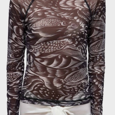 Blusa transparente com padrão de peixes cinza e preto usada com saia branca com nó