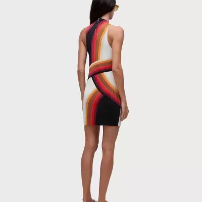 Vestido curto colorido com padrão ondulado e sapatos beje.