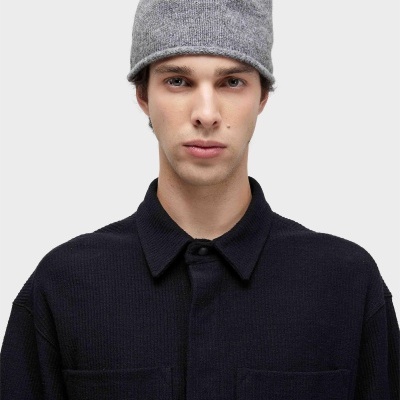 Homem com gorro cinzento de malha e camisa preta de malha