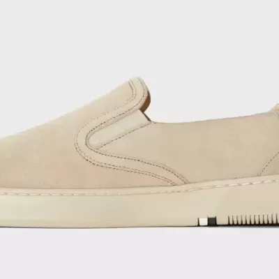 Sapato slip-on em camurça bege com sola branca e elástico lateral