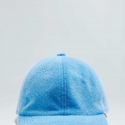 Boné azul em tecido felpudo sobre superfície branca
