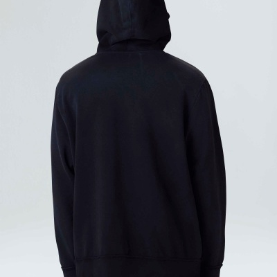 Casaco com capuz preto visto de costas com calças pretas e brancas