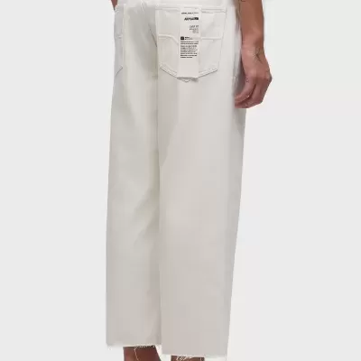 Calças brancas largas com etiqueta no bolso traseiro