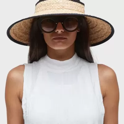 Mulher com chapéu de palha largo e óculos de sol redondos