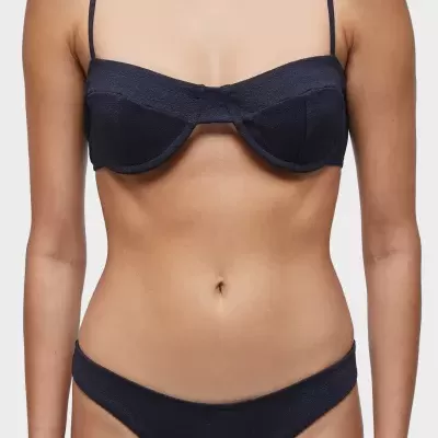 Pessoa com biquíni preto texturizado em fundo branco