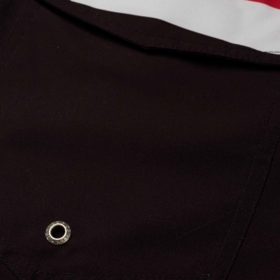 Pormenor de tecido preto com faixa vermelha e branca e etiqueta OSKLEN SURFING