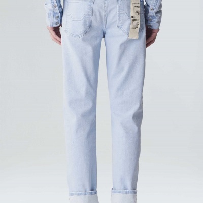 Calças de ganga azul claro com etiqueta pendurada no bolso traseiro