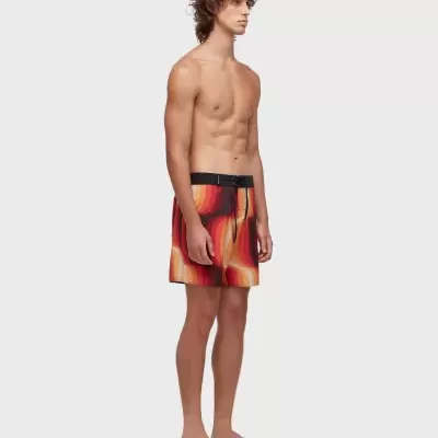 Modelo masculino com calções de banho coloridos e chinelos pretos