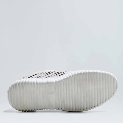 Sola branca de calçado com riscas e furos visível