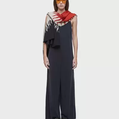 Mulher com macacão preto, lenço colorido e óculos amarelos