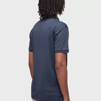 Homem de costas com polo azul escuro e calças claras
