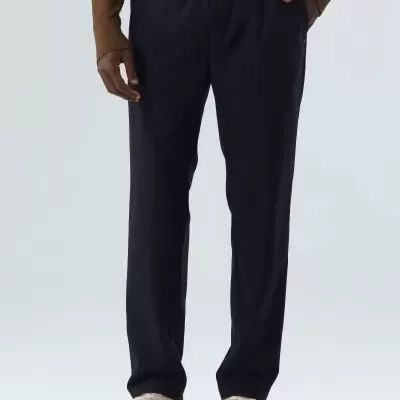 Calças pretas com bolsos usadas por modelo com sapatos brancos