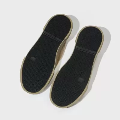 Solas de sapatos preto com borda bege sobre fundo branco