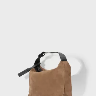 Mala castanha de camurça com alça preta e etiqueta pendurada