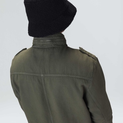 Pessoa de costas com chapéu preto e casaco verde-oliva