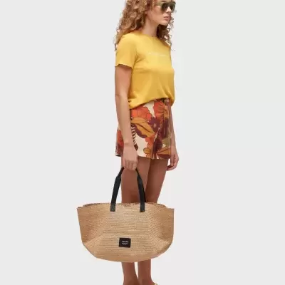 Mulher com roupa de verão e bolsa de palha