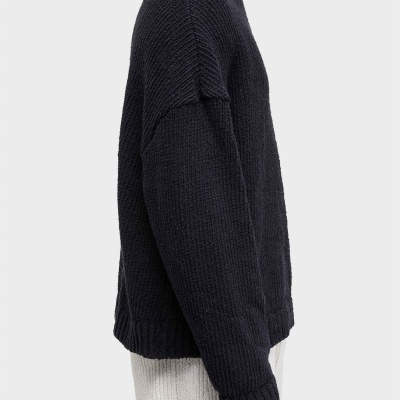 Camisola de malha grossa preta com gola redonda vista de perfil