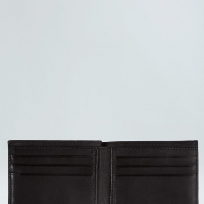 Carteira masculina preta aberta em couro com compartimentos para cartões.