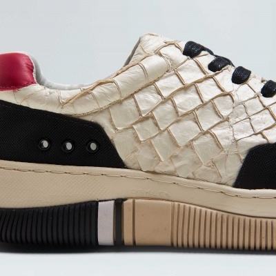 Tênis creme com padrão crocodilo, detalhes pretos e vermelhos, sola castanha e preta