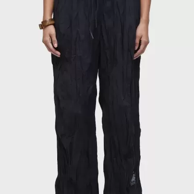 Calças pretas vincadas com cós elástico e cordão