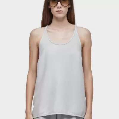 Mulher a usar t-shirt cinzenta clara sem mangas e óculos de sol com fundo branco