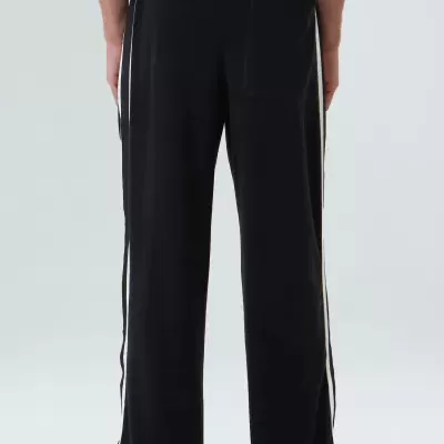 Calças largas pretas com riscas brancas laterais vistas de trás