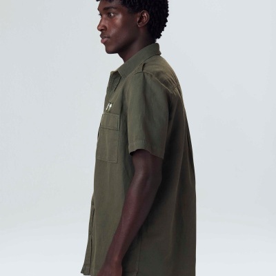 Camisa verde-oliva de manga curta vista de perfil em modelo masculino