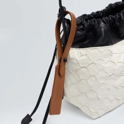 Saco de mão preto e branco com alça castanha e textura em escamas
