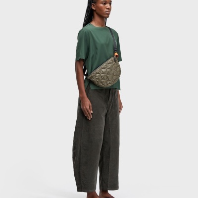 Modelo com roupa casual e bolsa matelassê verde