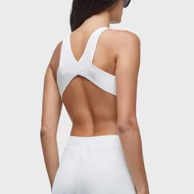 Top branco com alças largas cruzadas e calças brancas em tecido texturado