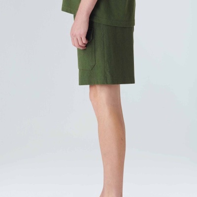 Modelo de lado com calções e t-shirt verde escura e mocassins bege com sola branca.