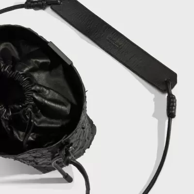 Mala preta com textura de pele de crocodilo e alça ajustável