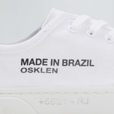 Ténis branco em tecido com texto preto e sola branca com gravação