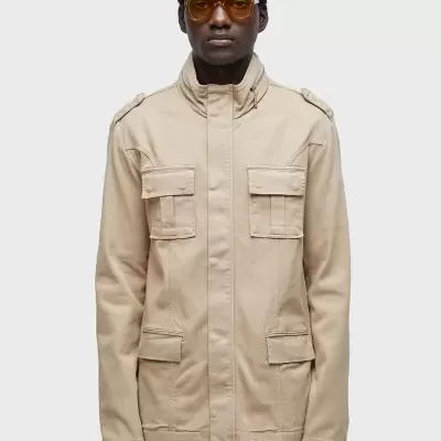 Casaco bege com bolsos de aba e alças nos ombros em modelo masculino