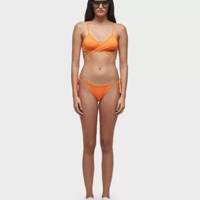 Mulher com fato de banho laranja e óculos escuros