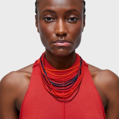 Colar colorido de contas usado com vestido vermelho