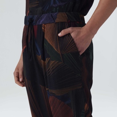 Calças compridas com padrão de folhas em tons escuros e cós elástico