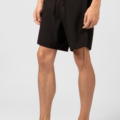 Calções pretos de tecido liso com cordão na cintura, em modelo masculino