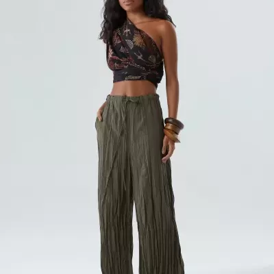 Calças largas verdes com textura vincada e top preto estampado num só ombro