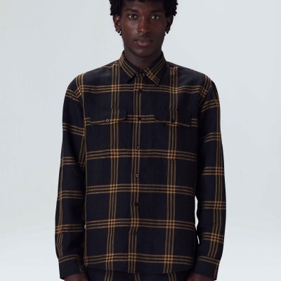 Homem a usar camisa xadrez preta e castanha com calças combinando