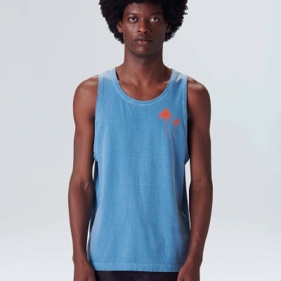 Homem a usar regata azul clara com palmeiras laranja e calções pretos em fundo branco