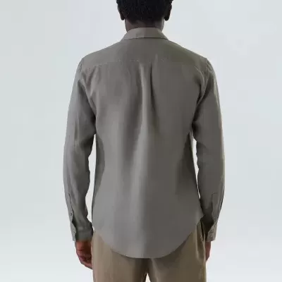 Homem de costas com camisa cinzenta e calções bege em fundo branco