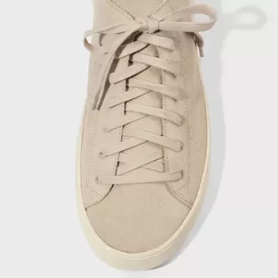 Ténis bege claro em camurça com atacadores e sola branca, vista de cima