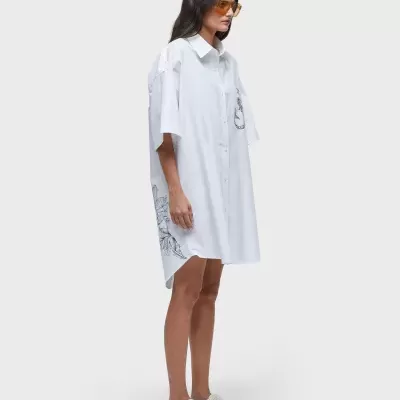 Vestido camisola branco com ilustração preta usado por modelo com óculos amarelos e sapatilhas brancas