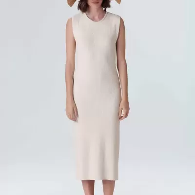 Vestido midi branco sem mangas com malha canelada, chapéu de palha e sapatos bege numa modelo feminina