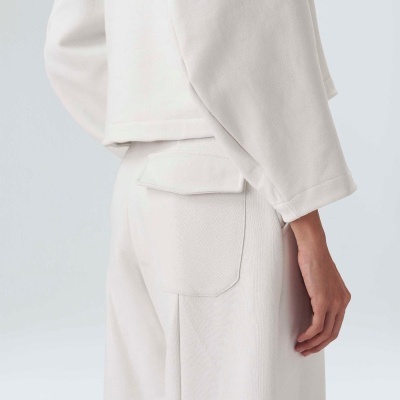 Roupa casual branca com calças e parte superior de tecido liso e bolso traseiro com aba