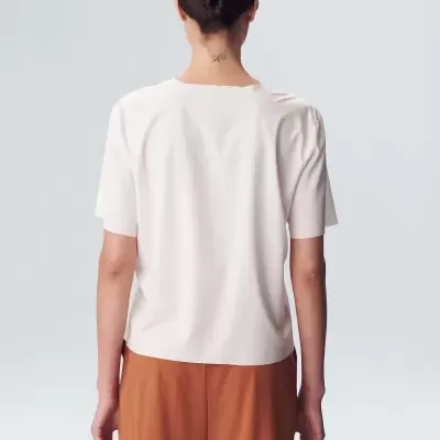 Pessoa de costas com t-shirt branca e calças castanhas