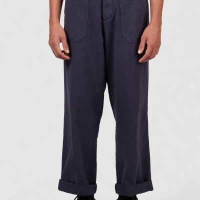 Calças largas azuis escuras com bainha dobrada e ténis pretos