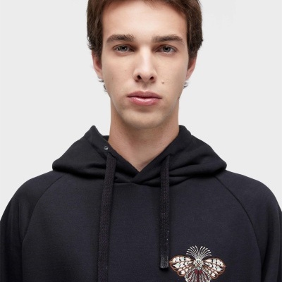 Sweatshirt preta com bordado colorido de borboleta na frente e capuz.